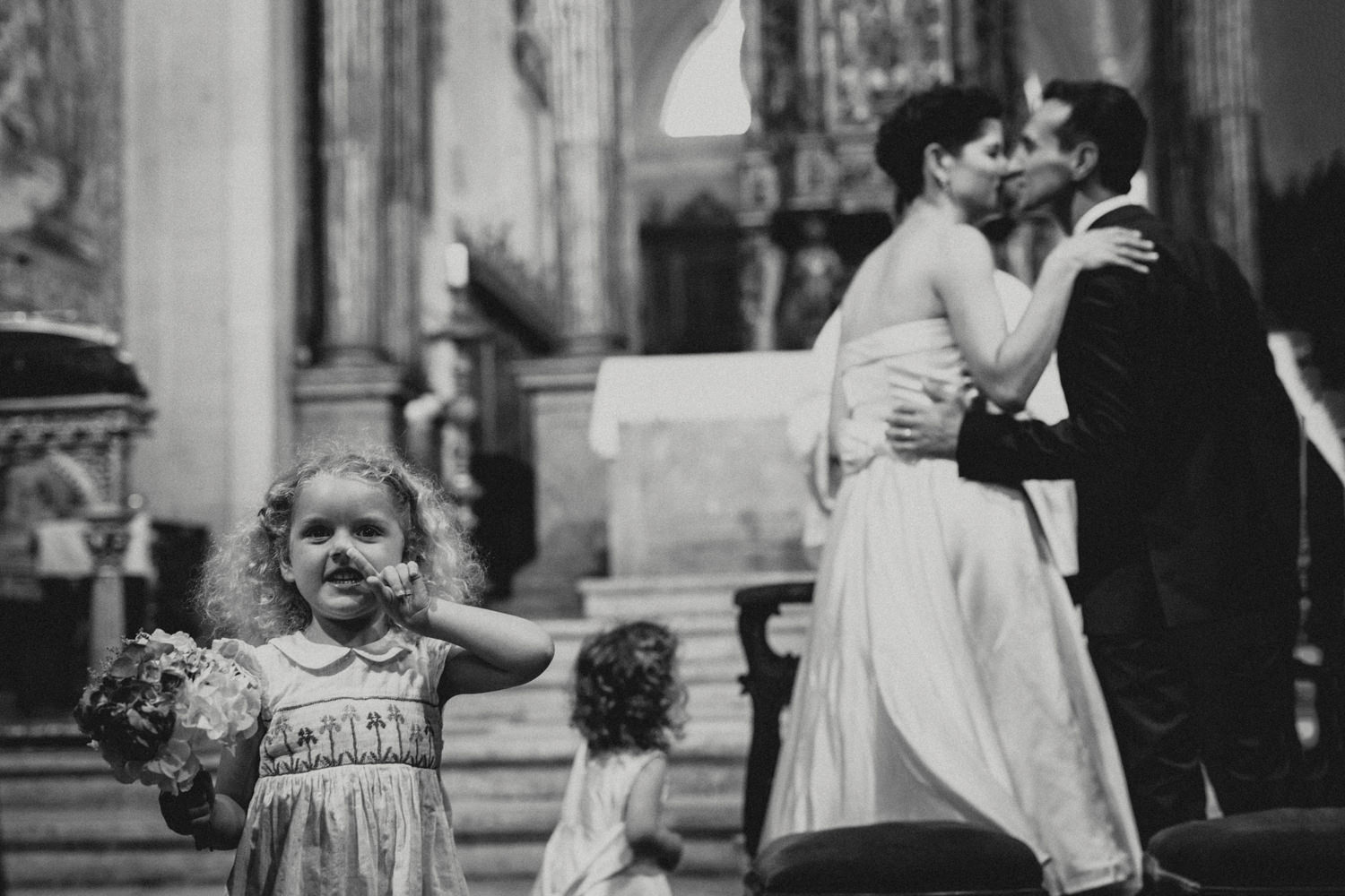 flower girl picking nose during couples first kiss