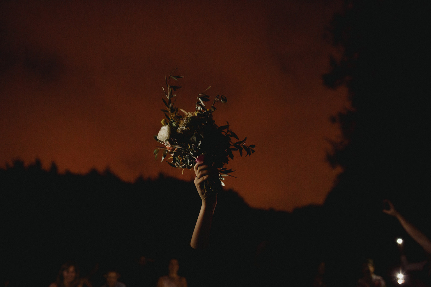 bride throwing her bouquet at night after outdoor wedding ceremony in porto portugal