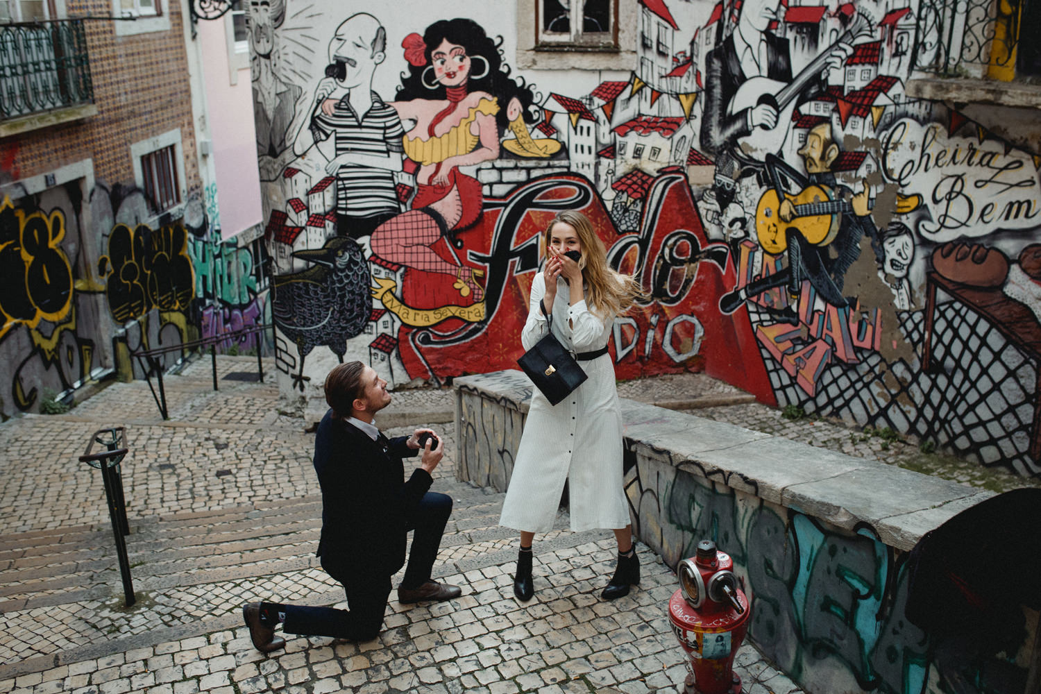 emotional proposal in lisbon portugal in front of a graffiti wall