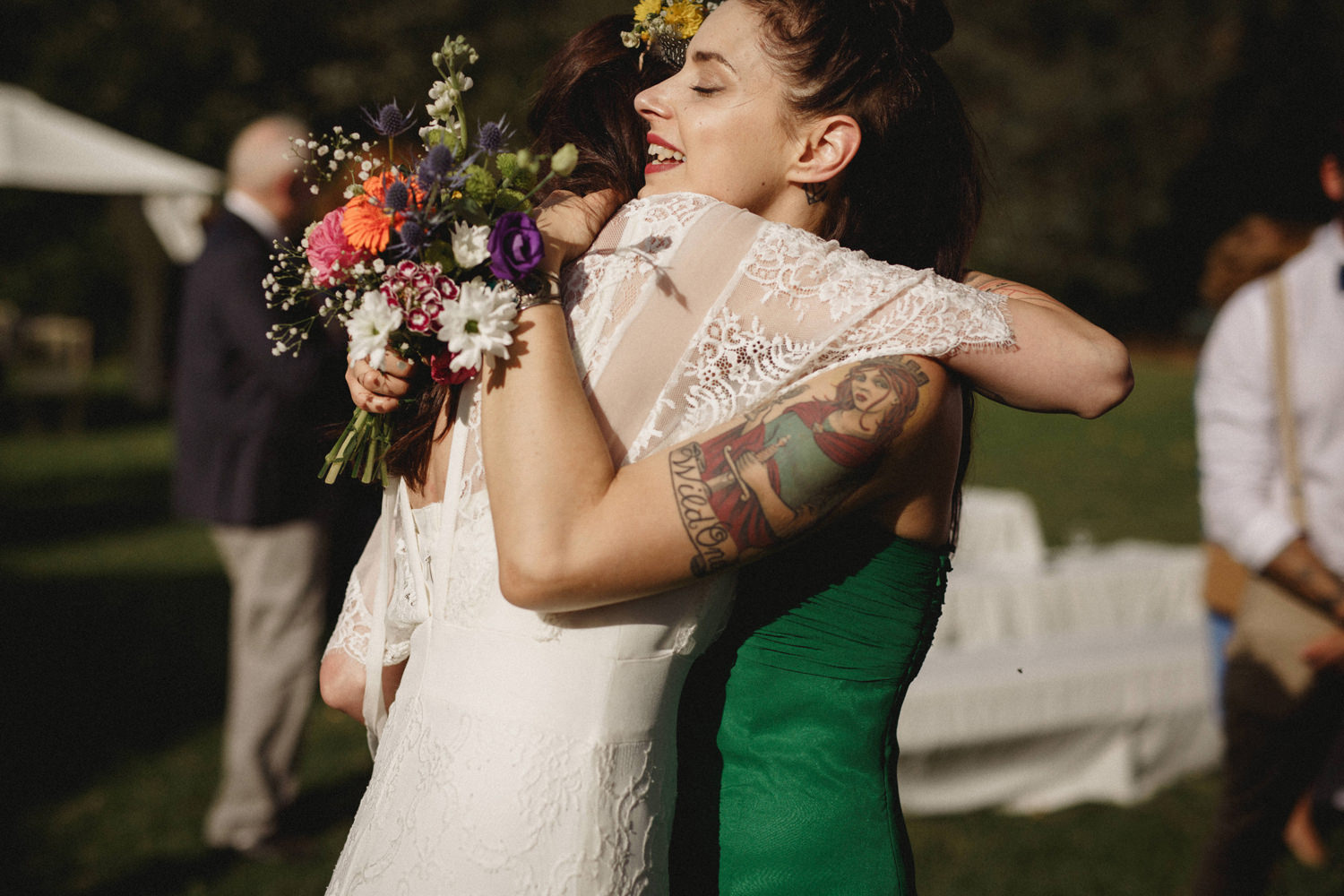 boho bride hugging tattooed bridesmaid in portugal